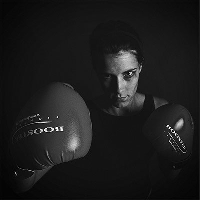 black and white photo of a female mannequin with a blackened eye with his boxing gloves in the foreground copyright Claude HALET studio Mamiya
