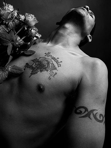 black and white portrait taken from underneath a black man whose chest is tattooed with a rose named Herminia shot in studio Halet
