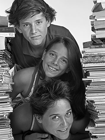 black and white portrait of a young man and two girls lying on each other surrounded by comic books column copyright Claude HALET